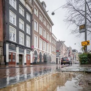 a city street with a puddle of water on the street at Hotel Oscar in Amsterdam