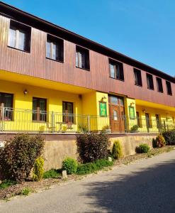 un grande edificio con un giallo e un marrone di Penzion PANORAMA Janovičky a Broumov