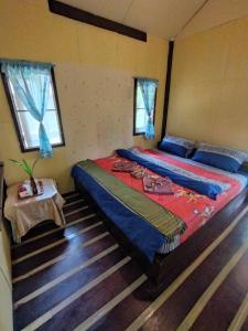 a bedroom with two beds and a table in it at Eco Bungalow in Ko Phayam