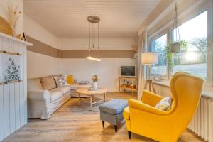 诺德奈Vorderhuus的客厅里有一把黄色的椅子和一张沙发