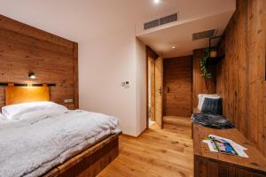 a bedroom with a bed and a wooden wall at JOHAN HOTEL in Zlín
