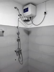 a shower in a white bathroom with a machine at Ella Mount Villa in Ella