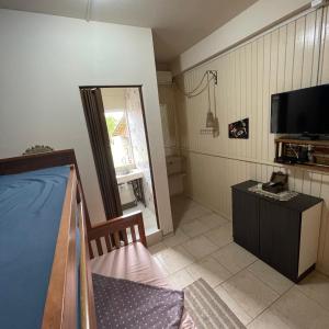 a small room with a bed and a television at Bell vale in Louro Müller