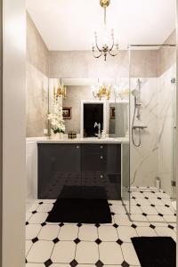 a bathroom with a shower and a sink and a chandelier at Bea Home Elblag - dwie sypialnie in Elblag