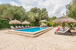 a swimming pool with chairs and umbrellas at Finca Es Rafalot de Dalt by Mallorca House Rent in Manacor