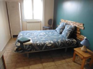 a bedroom with a bed with a blue wall at agréable maison de famille in Sigean