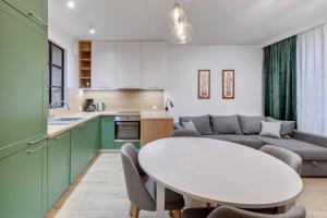 kuchnia i salon ze stołem i kanapą w obiekcie Comfort Apartments Wilcza w Gdańsku