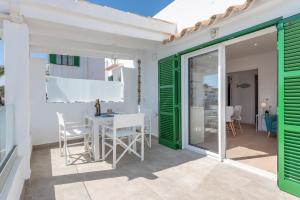ein Esszimmer mit grünen Türen sowie einem Tisch und Stühlen in der Unterkunft Apartment Sa Caseta 1 by Mallorca House Rent in Portopetro