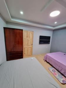 a bedroom with a bed and a cabinet at Trésor Caché TT in Claxton Bay
