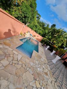 a swimming pool on a stone walkway next to a building at Trésor Caché TT in Claxton Bay