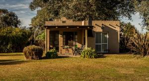a small house with a porch and a table at La Pausa Lodge de Campo in Duggan