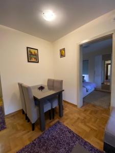 a dining room with a table and chairs and a bedroom at Apartman Ana in Vrnjačka Banja
