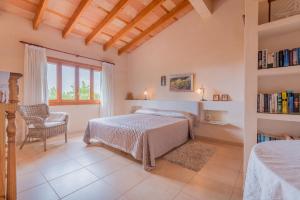 a bedroom with a bed and a chair and a book shelf at Finca Puig de l'Anar in Manacor +25 photos