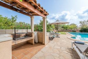an outdoor patio with a swimming pool and an umbrella at Finca Puig de l'Anar in Manacor