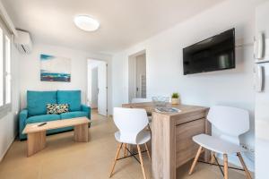 a living room with a blue couch and a table and chairs at Apartment Sa Caseta 3 by Mallorca House Rent in Portopetro