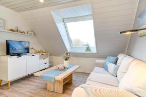 sala de estar con sofá y TV en Ferienhaus Blumenmeer, en Norderney