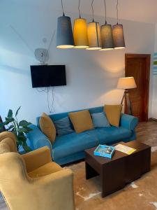 a living room with a blue couch and a coffee table at Apartmani Sport Igalo in Herceg-Novi