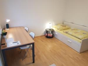 Cette petite chambre comprend un lit et un bureau. dans l'établissement Zimmer 2 nahe Thoraxklinik - Bad und Küche geteilt, à Heidelberg