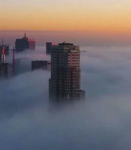 a building in the middle of the fog at sunset at Romantic room in brussels sky in Brussels