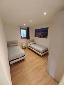 a bedroom with two beds and a chair in it at Sclap Appartamenti - Livigno in Livigno