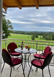 una mesa y sillas en un balcón con vistas en Haus Sonnentau Wohnung 2, en Kisslegg