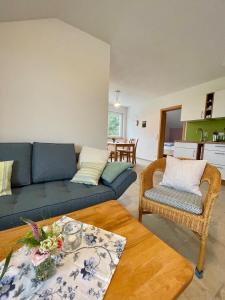 sala de estar con sofá azul y mesa en Haus Sonnentau Wohnung 2, en Kisslegg