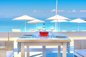 uma mesa com uma garrafa de vinho e copos numa praia em Laza Beach em Skala