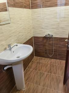 La salle de bains est pourvue d'un lavabo blanc et de parquet. dans l'établissement Винарна-Славовица, à Kalugerovo