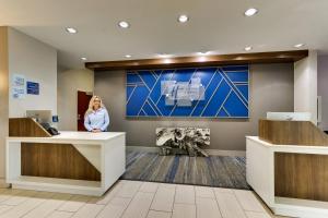 a woman standing at a reception desk in a lobby at Holiday Inn Express & Suites - Ardmore, an IHG Hotel in Ardmore