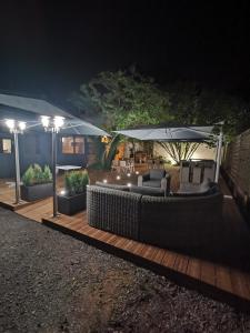 une terrasse avec un parasol, des chaises et des tables dans l'établissement Le P'tit Bouchon, à Rambervillers