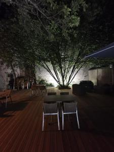 a patio with chairs and a table and a tree at Le P'tit Bouchon in Rambervillers