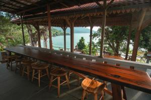 a long bar with stools and a view of the water at Legon Waru Cottage in Karimunjawa