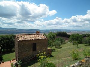 un pequeño edificio de piedra en medio de un campo en Agriturismo Riposati, en Monticchiello