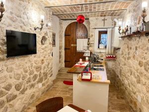 a kitchen with stone walls and a tv on the wall at B&B Casa Antonetti in Campo di Giove