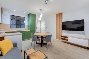 kuchnia i salon ze stołem i telewizorem w obiekcie Comfort Apartments Wilcza w Gdańsku
