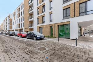 ulica z samochodami zaparkowanymi przed budynkami w obiekcie Comfort Apartments Wilcza w Gdańsku