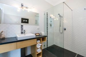 La salle de bains est pourvue d'un lavabo et d'une douche. dans l'établissement Seascape Accommodation, à Portland