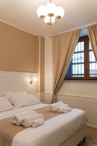 une chambre avec un grand lit avec des serviettes dessus dans l'établissement Mama House, à Milan