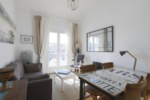 uma sala de estar com uma mesa e um sofá em Joli appartement avec magnifique vue em Saint-Martin-de-Ré