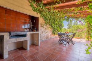 an outdoor patio with a table and a fireplace at Es Reguerons Gran in Felanitx