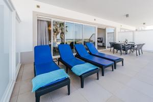 オビドスにあるBeachfront Atlantic View A09の青い椅子と景色の見えるテーブルのある部屋