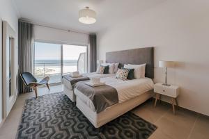 オビドスにあるBeachfront Atlantic View A09の海が見える大きなベッドのある寝室