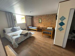 1 dormitorio con cama y pared de ladrillo en Bell vale, en Lauro Müller