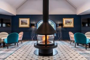 
a fire place in the middle of a room at The Coniston Hotel Country Estate & Spa - Skipton in Gargrave
