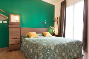 a green bedroom with a bed and a green wall at Il Sogno Apartments in Marsala