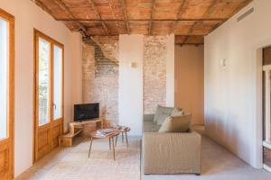 ein Wohnzimmer mit einem Sofa und einem TV in der Unterkunft LaComuna City Oasis in Girona