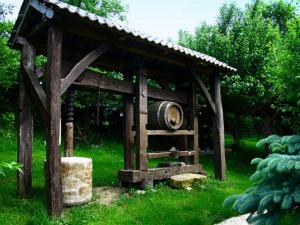 a wooden gazebo with a barrel in the grass at Stara Vodenica in Klanjec