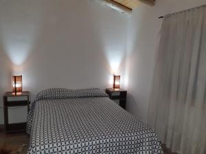 a bedroom with a bed and two lamps on tables at El Nevado Casa de Campo 2 in San Rafael