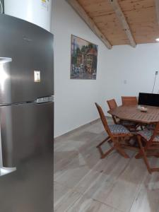 een keuken met een tafel en een roestvrijstalen koelkast bij El Nevado Casa de Campo in San Rafael