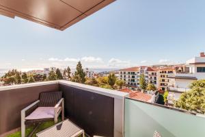 a balcony with a chair and a view of the city at RYM Apartment - Madalenas in Funchal